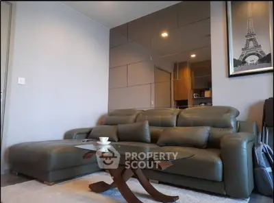 Stylish living room with modern leather sofa and elegant glass coffee table.
