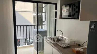 Compact kitchen with balcony access, featuring modern appliances and sleek design for urban living.