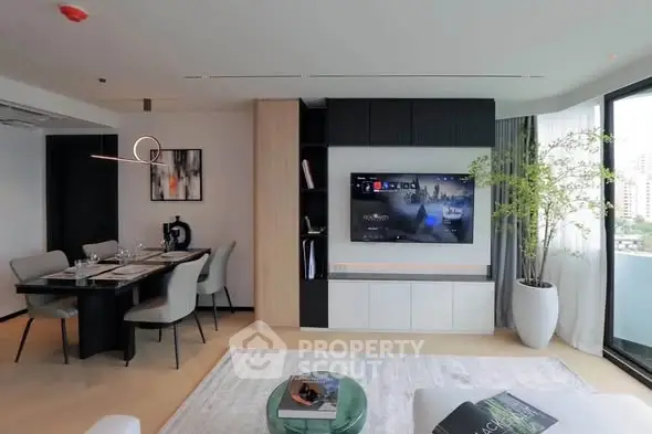 Modern living room with open layout, stylish dining area, and large TV, perfect for entertaining.