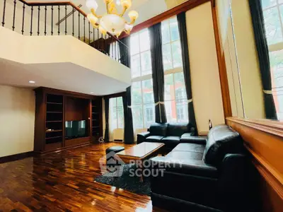 Luxurious living room with high ceilings, elegant chandelier, and large windows for natural light.