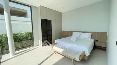 Luxurious bedroom with modern design and large window offering natural light