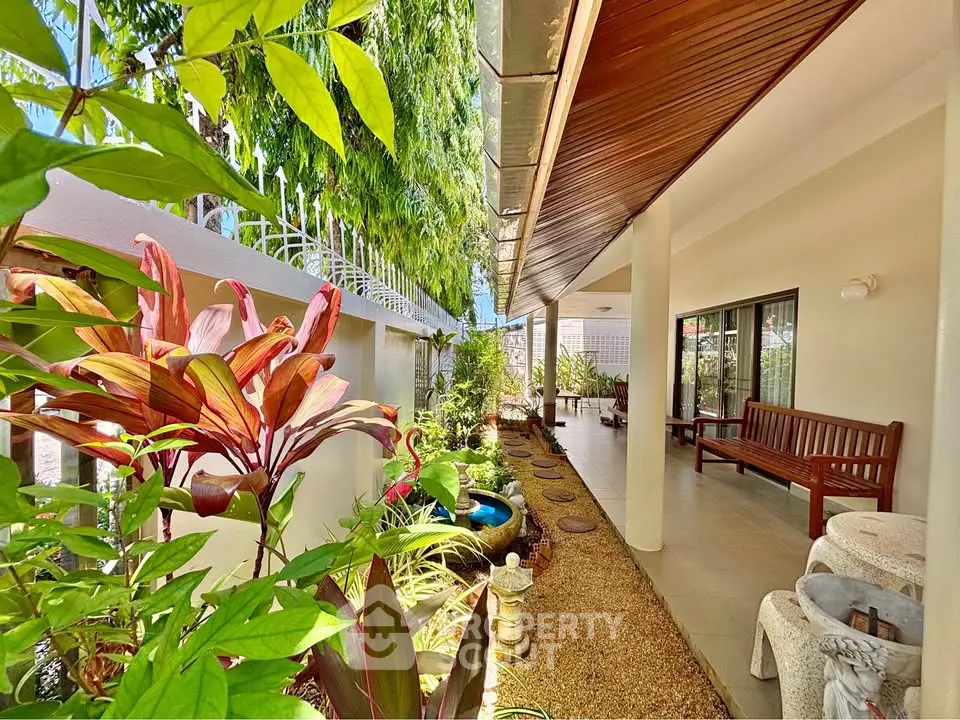 Charming garden view with lush greenery and cozy outdoor seating area in a serene residential setting.