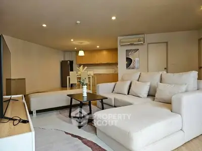 Spacious modern living room with cozy sectional sofa and open kitchen layout.