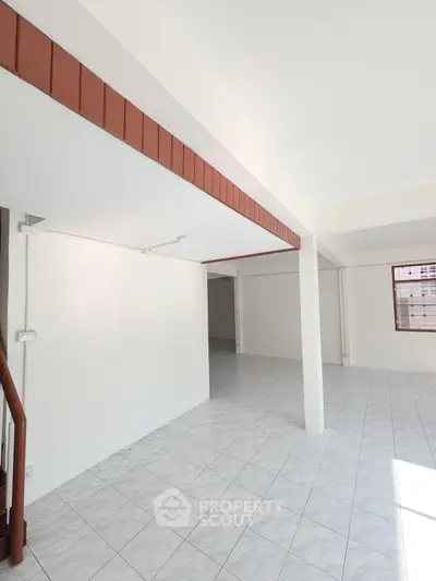 Spacious open-plan interior with tiled flooring and ample natural light.
