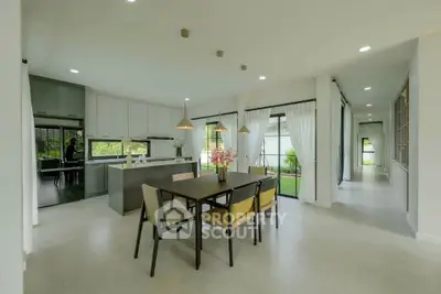 Spacious modern dining area with open kitchen and garden view, perfect for family gatherings.