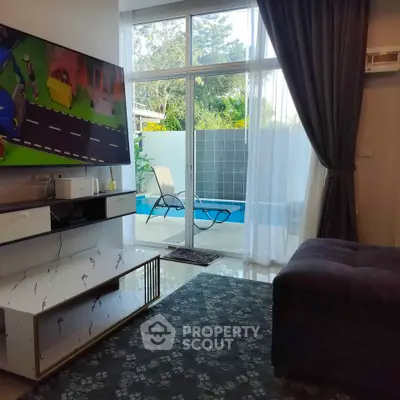 Modern living room with pool view, large TV, and stylish decor