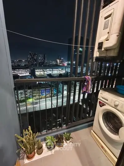Charming balcony with city view, featuring washing machine and potted plants, perfect for urban living.