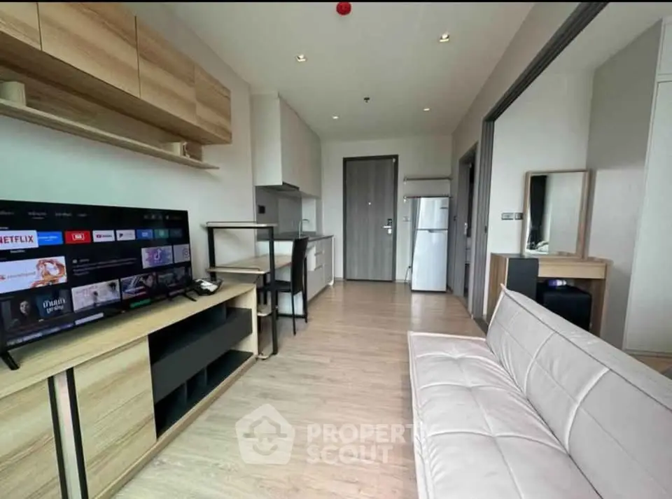 Modern living room with sleek furniture and open kitchen layout in a stylish apartment.