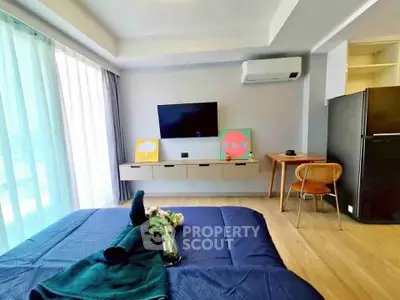 Modern bedroom with stylish decor, featuring a wall-mounted TV, air conditioning, and a cozy workspace.