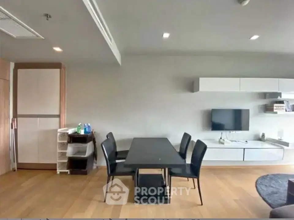 Modern living room with sleek furniture and wall-mounted TV in a stylish apartment.