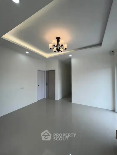 Spacious modern living room with elegant chandelier and sleek tile flooring