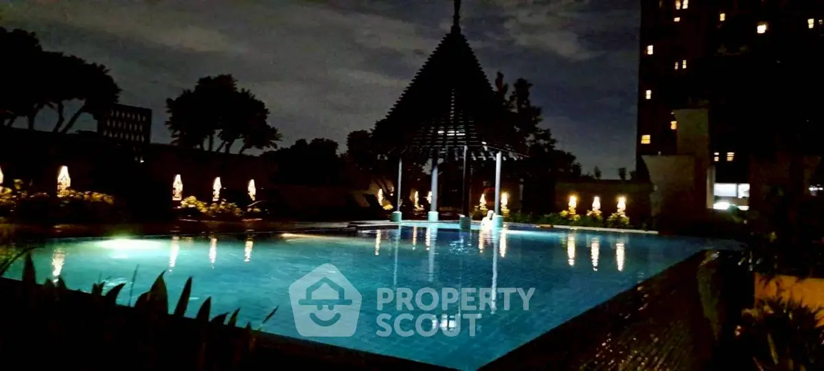 Luxurious night view of illuminated swimming pool with elegant gazebo and ambient lighting.