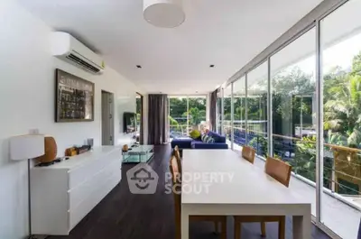 Spacious modern living room with large windows and balcony view