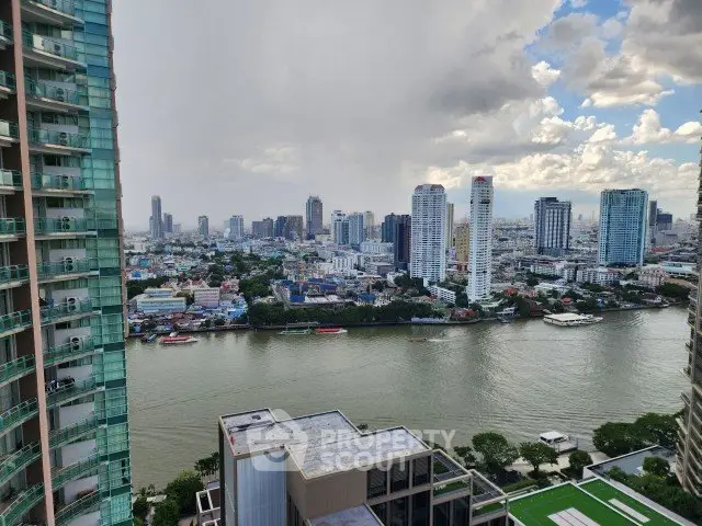 Stunning cityscape view from high-rise balcony overlooking river and skyline.