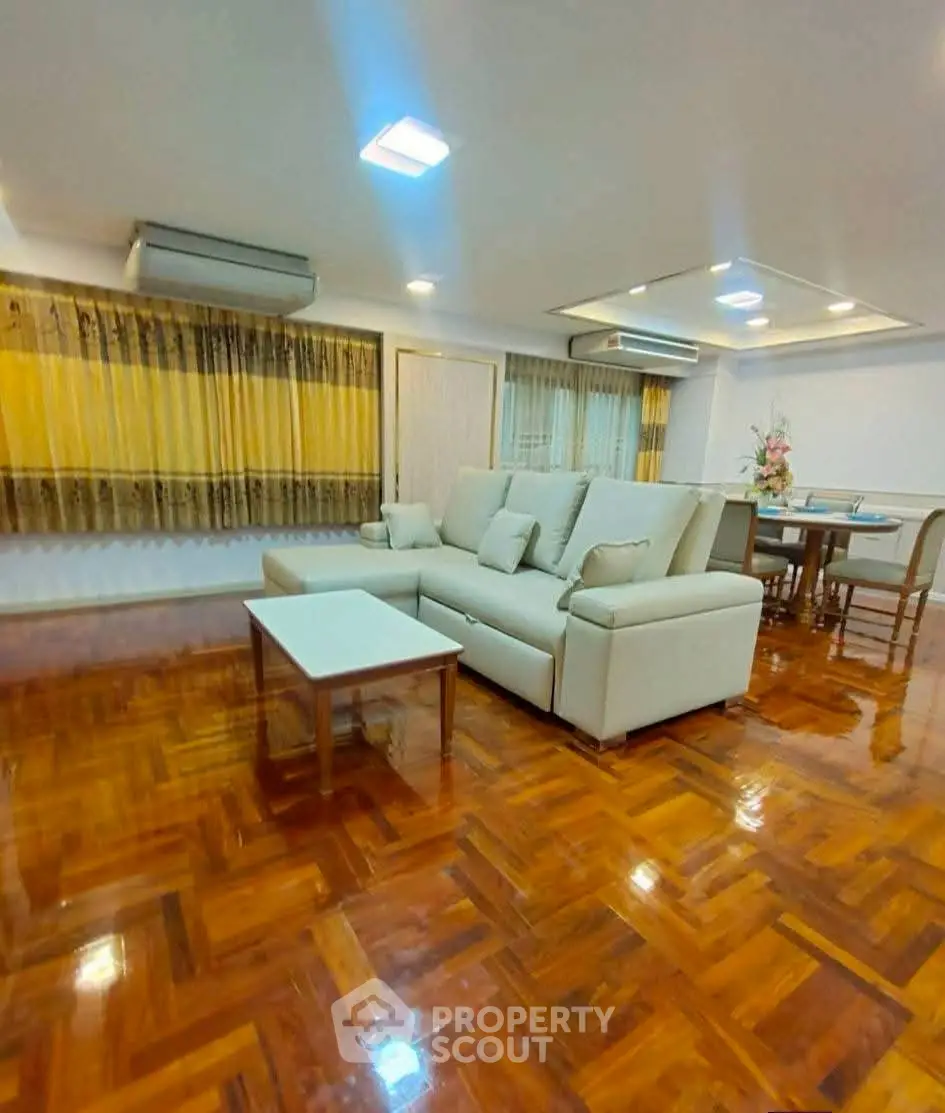 Spacious living room with elegant wooden flooring and modern furniture