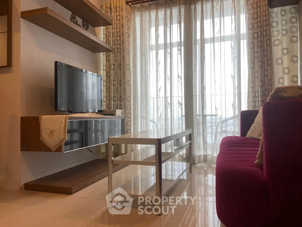 Cozy living room with modern TV setup and elegant curtains