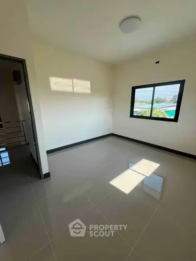 Spacious empty room with large window and glossy tiled floor, perfect for customization.