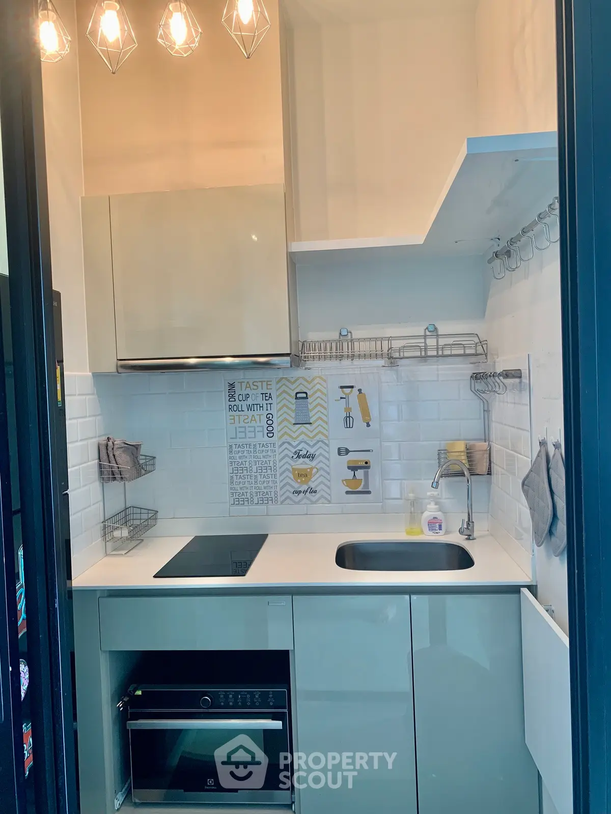 Modern compact kitchen with sleek cabinetry and built-in appliances, featuring a stylish backsplash and efficient layout.