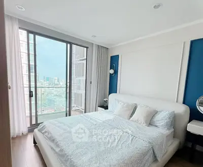 Modern bedroom with large windows and city view, featuring elegant decor and natural light.