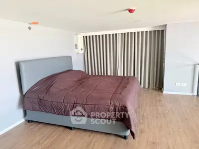 Spacious bedroom with modern design and cozy ambiance, featuring a large bed and elegant flooring.