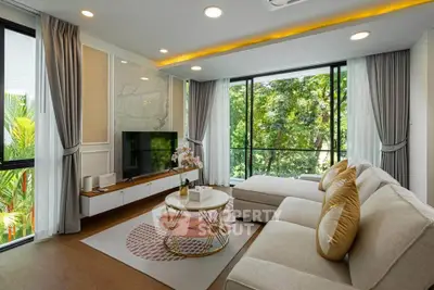 Luxurious living room with large windows and modern decor, offering a serene garden view.