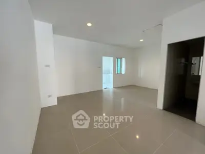 Spacious unfurnished room with tiled flooring and bright lighting, ideal for customization.