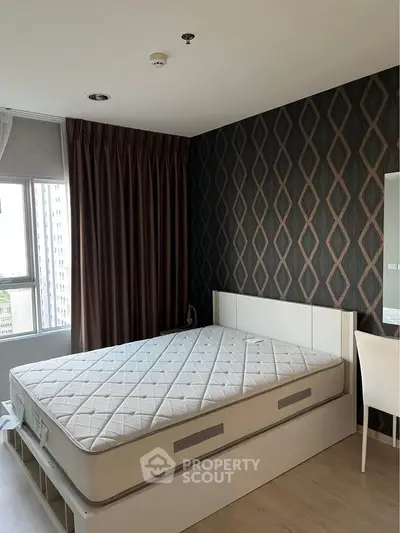 Modern bedroom with stylish wallpaper and large window offering natural light.