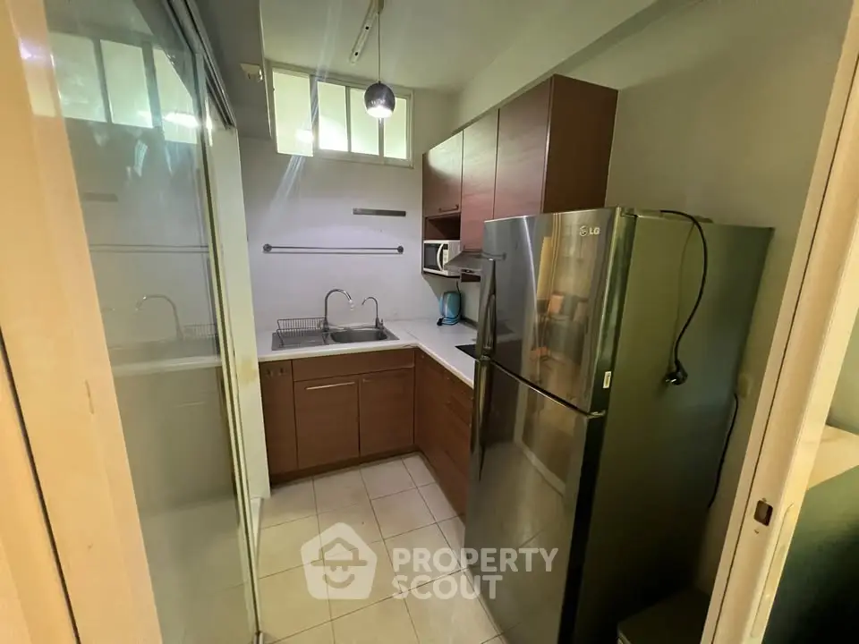 Compact kitchen with modern appliances and sleek cabinetry in a cozy apartment setting.