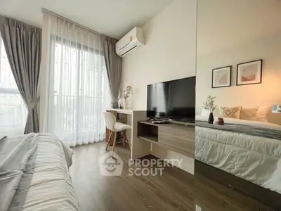 Modern bedroom with TV, desk, and large window for natural light