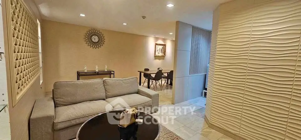 Stylish living room with modern decor and dining area, featuring elegant wall textures and contemporary furniture.