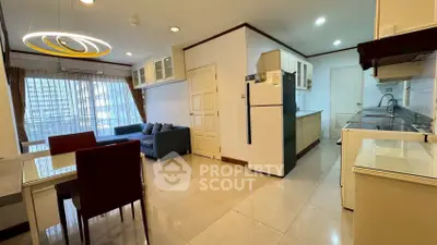 Spacious open-plan living room and kitchen with modern furnishings and large windows.