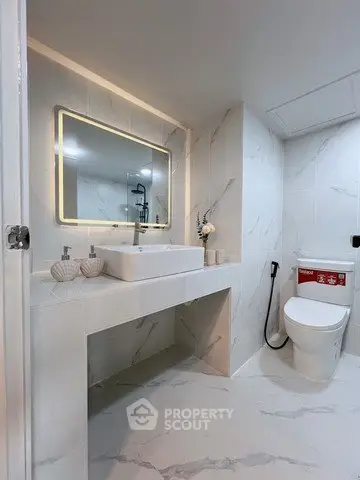 Modern bathroom with sleek design, featuring a large mirror and elegant fixtures.