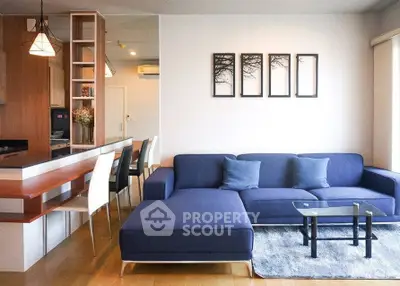 Modern living room with stylish blue sofa and open kitchen layout