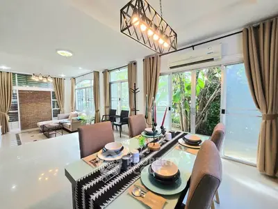 Spacious open-plan living and dining area with modern decor and large windows.