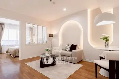 Modern living room with elegant decor and cozy seating area, featuring a stylish archway and natural light.
