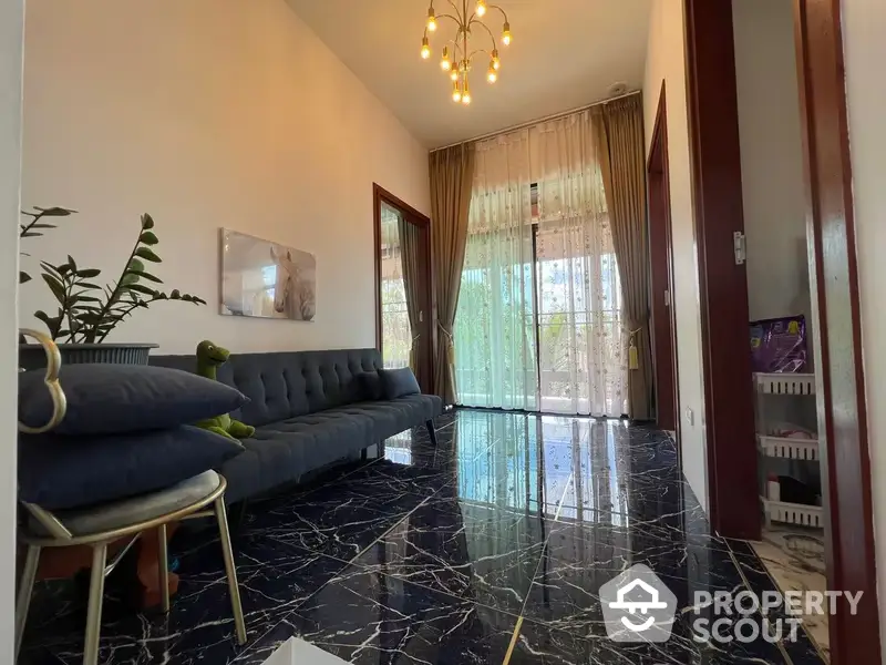 Elegant living room with polished black marble flooring, high ceiling, and large windows draped with sheer curtains, complemented by a chic blue sofa set.