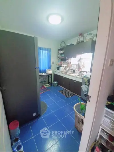 Cozy kitchen with blue tiled floor and modern appliances, perfect for culinary enthusiasts.