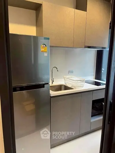 Modern compact kitchen with sleek cabinets and stainless steel appliances