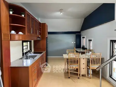 Spacious kitchen with wooden cabinets and dining area in modern home