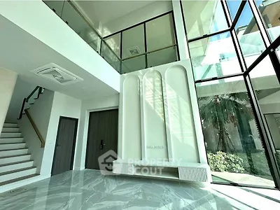 Luxurious modern interior with high ceilings and large windows offering garden views.