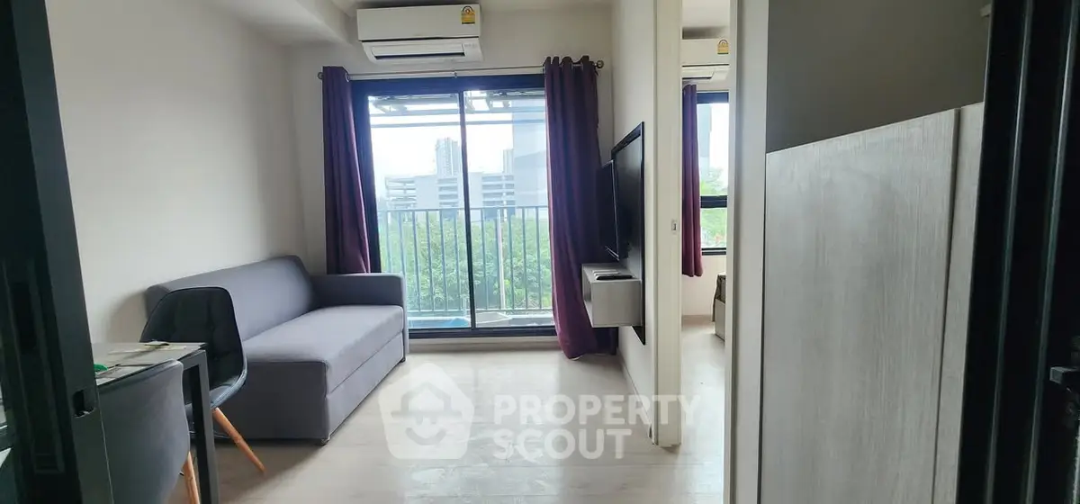 Modern living room with balcony view and sleek furnishings in urban apartment