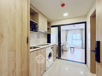 Modern kitchen with washing machine and open layout leading to bright living room