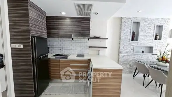 Modern kitchen with sleek wooden cabinets and dining area in stylish apartment.