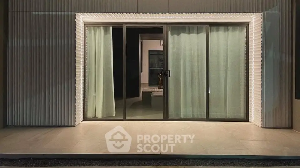 Modern sliding glass doors with elegant curtains in a contemporary home exterior.