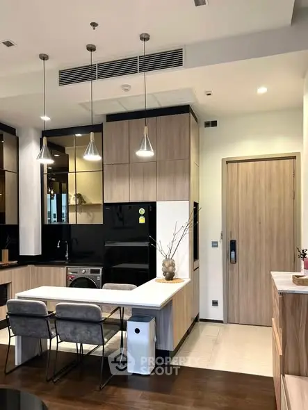 Modern kitchen with sleek design, featuring pendant lights and integrated appliances.