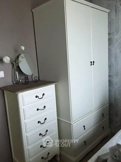 Elegant bedroom with classic white wardrobe and matching dresser, perfect for stylish storage solutions.