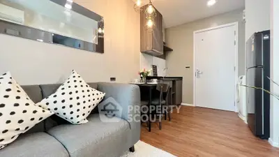 Modern living room with cozy sofa and stylish kitchen in open layout apartment.