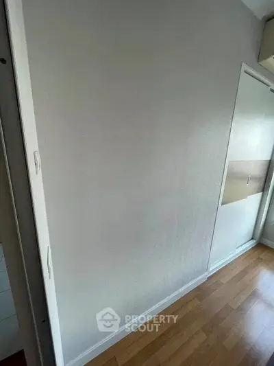 Minimalist room with wooden flooring and sliding closet doors