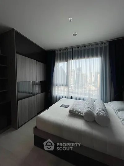 Modern bedroom with city view and sleek furniture design.
