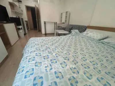 Cozy bedroom with modern furnishings and floral bedding in a compact apartment.